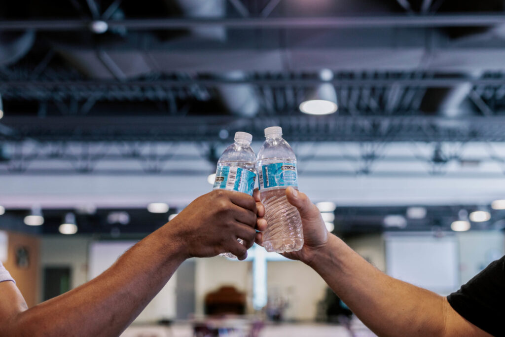 two men hold bottles of water